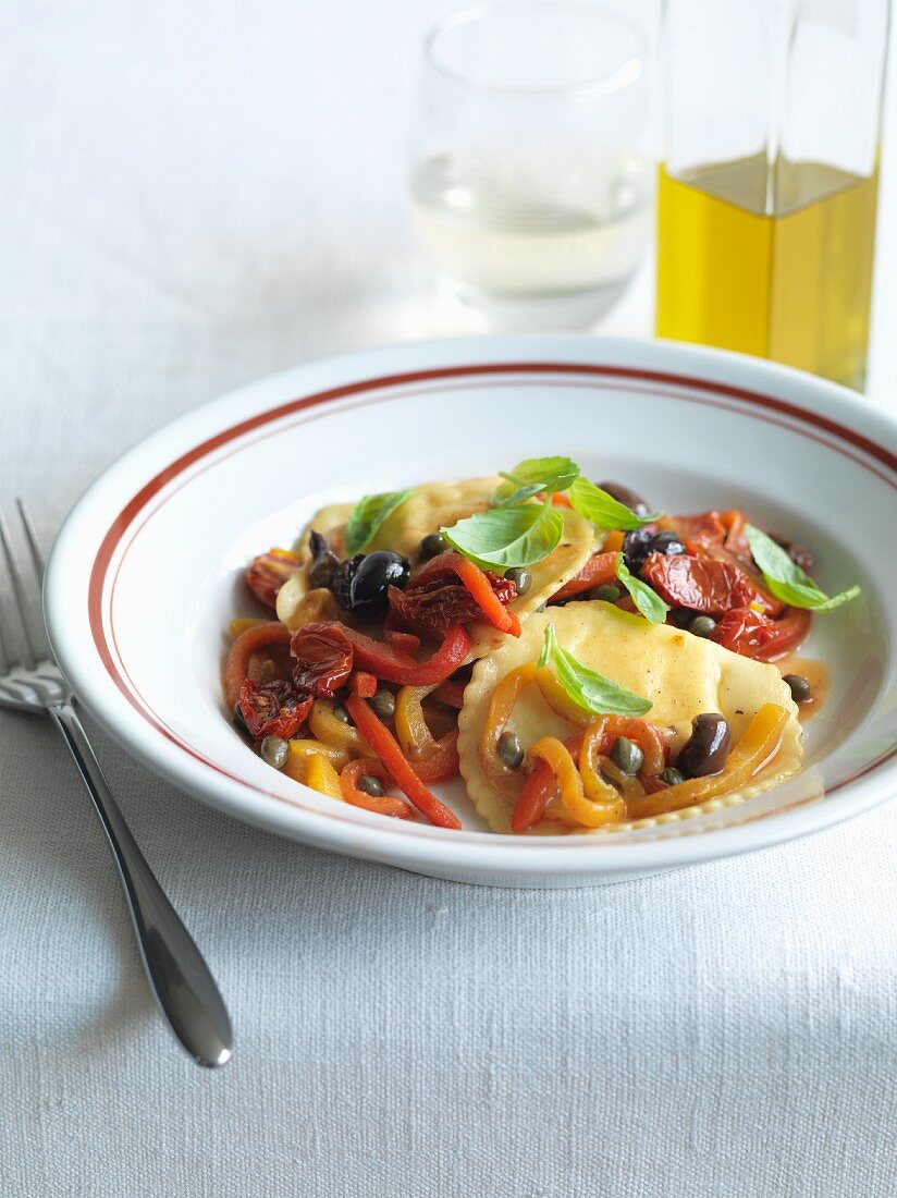 Pansotti alla genovese (pasta parcels with tomatoes, peppers and capers, Italy)