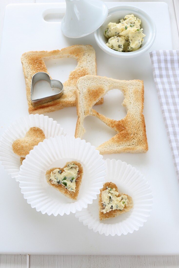 Hearts cut out of toast topped with herb butter as party food