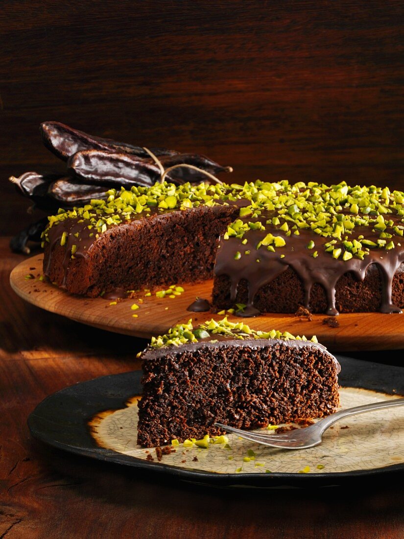 Carob cake with a chocolate glaze and pistachio nuts