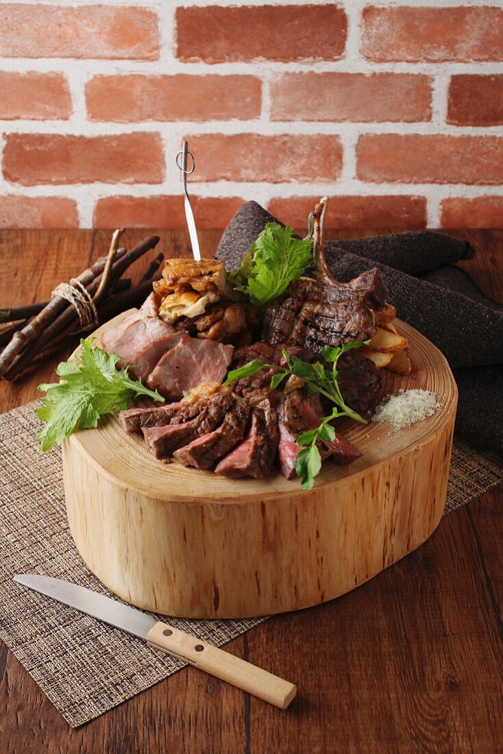 Sliced roast beef with chips on a round wooden block