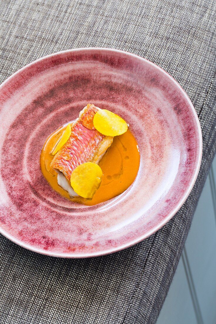 Red mullet with thinly sliced kohlrabi and Porthilly sauce in a restaurant