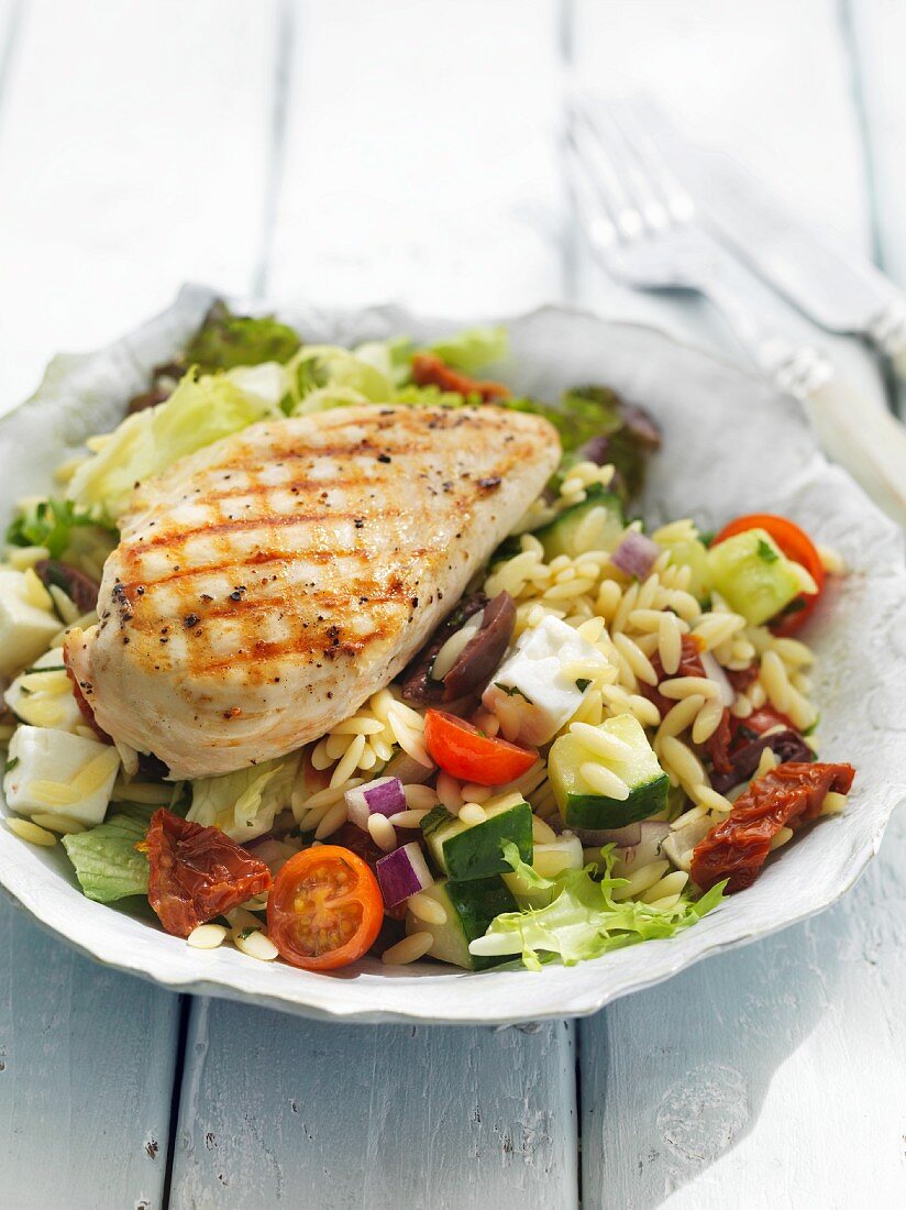 Orzo salad with fresh vegetables and grilled chicken breast