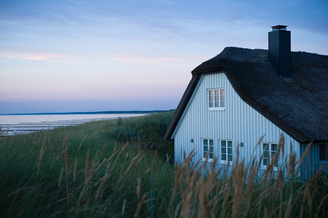 A thatched roof house in Ahrenshoop at dusk on the Baltic Sea