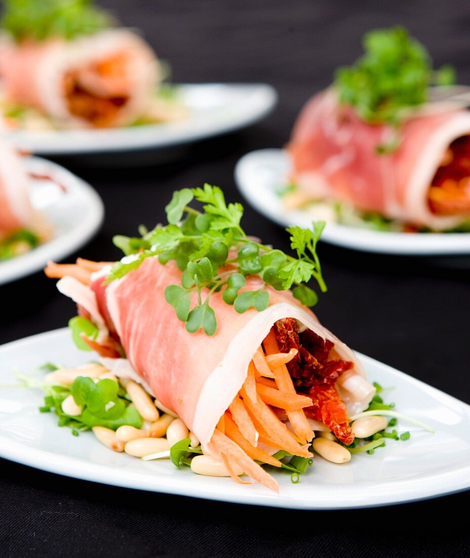 Parma ham rolls on a watercress salad with pine nuts