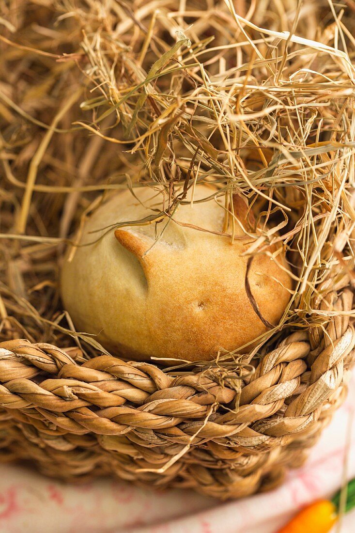 A rabbit-shaped bread roll with a carrot in an Easter basket