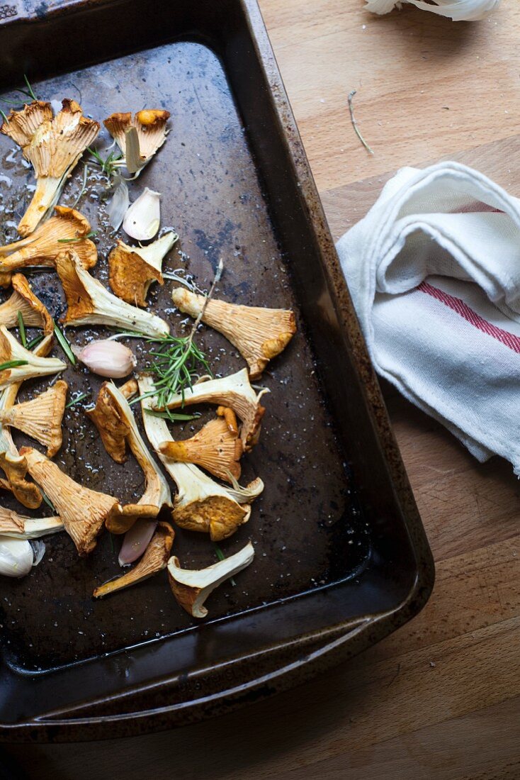 Chanterelle mushrooms with garlic and rosemary on a baking tray