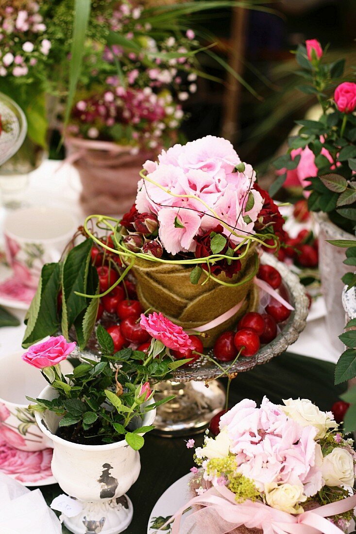 Summery arrangement of hydrangeas, roses and cherries