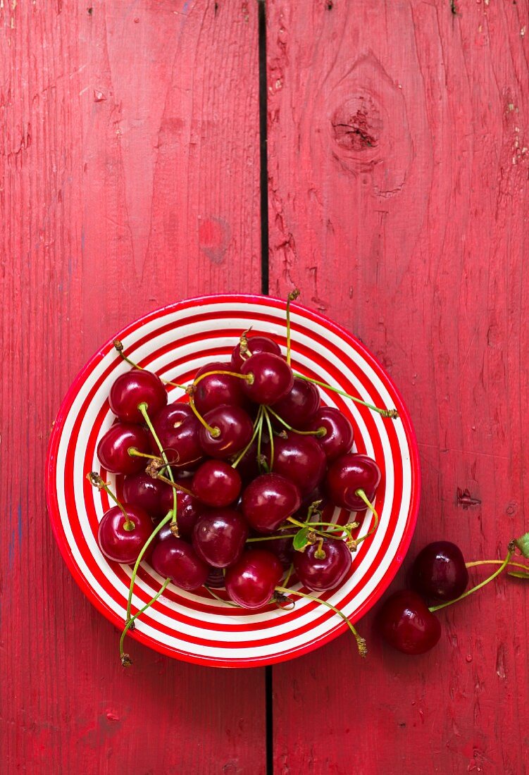 Fresh cherries on a stripped plate (seen from above)