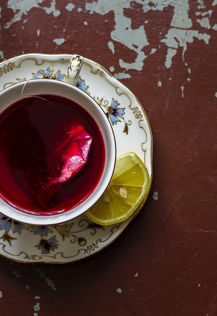A cup of fruit tea with a teabag