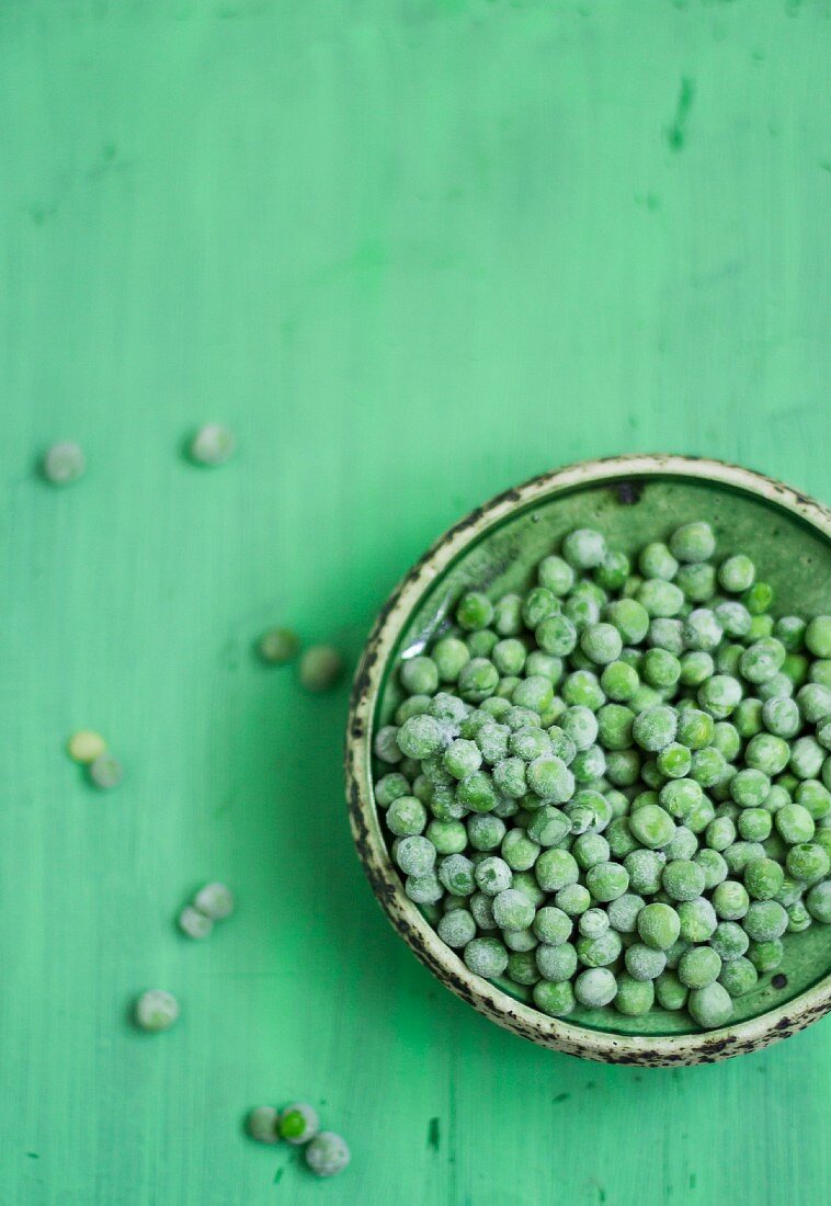 Frozen peas in a green bowl