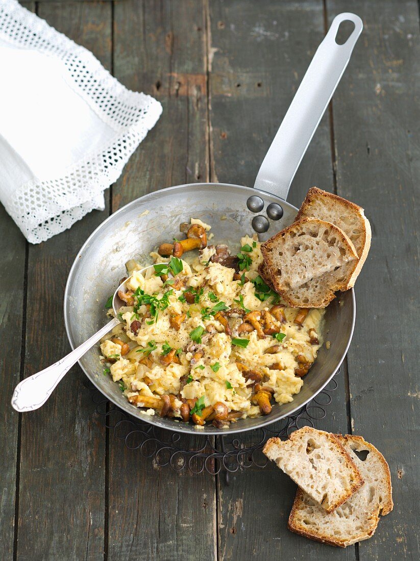 Scrambled eggs with chanterelle mushrooms served with bread