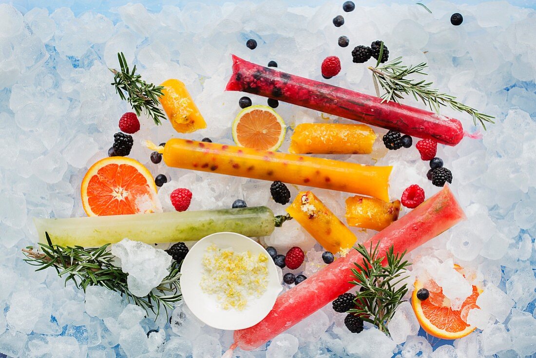 Ice lollies with berries and fruits on ice cubes