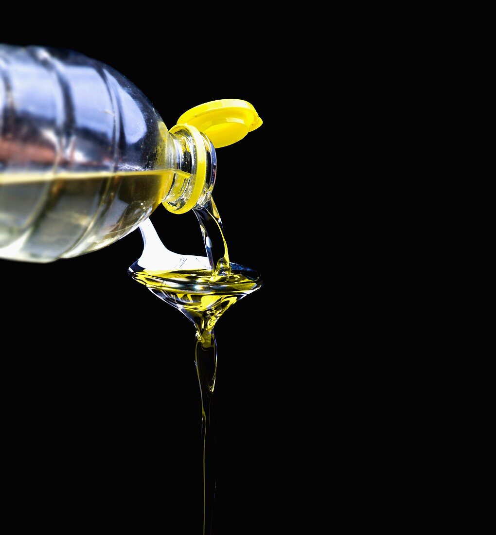 Oil being poured for plastic bottle onto a spoon