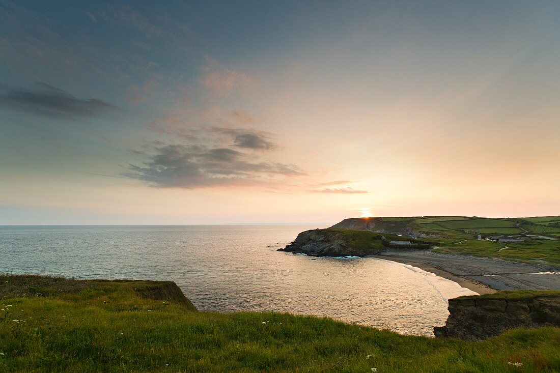 Küstenlinie von Gunwalloe bei Sonnenuntergang (Cornwall, England)