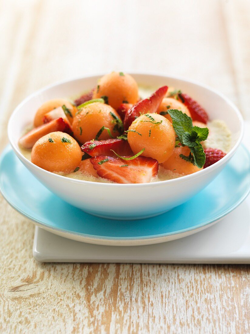 Cold melon and yogurt soup with strawberries and mint