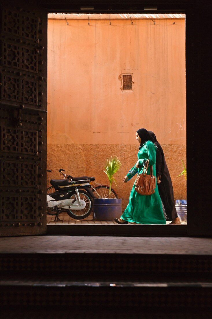 Blick durch Portal in eine belebte Gasse Marrakeschs, Marokko