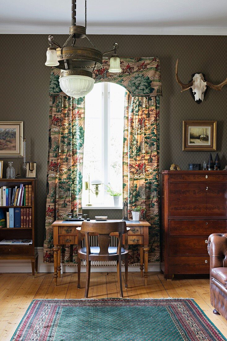 Rustic study with antique desk in front of window with pelmet and floor-length curtains