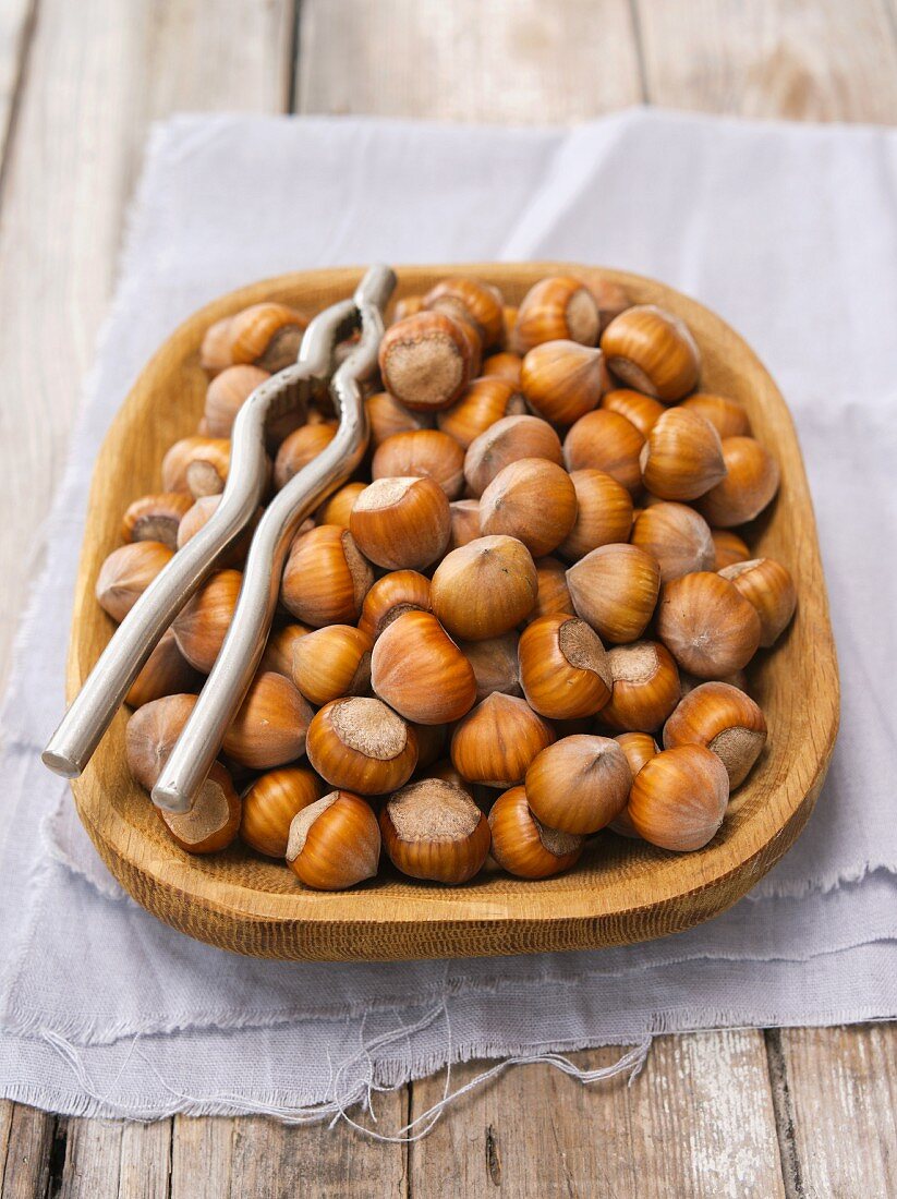 Hazelnuts in a wooden bowl with a nutcracker