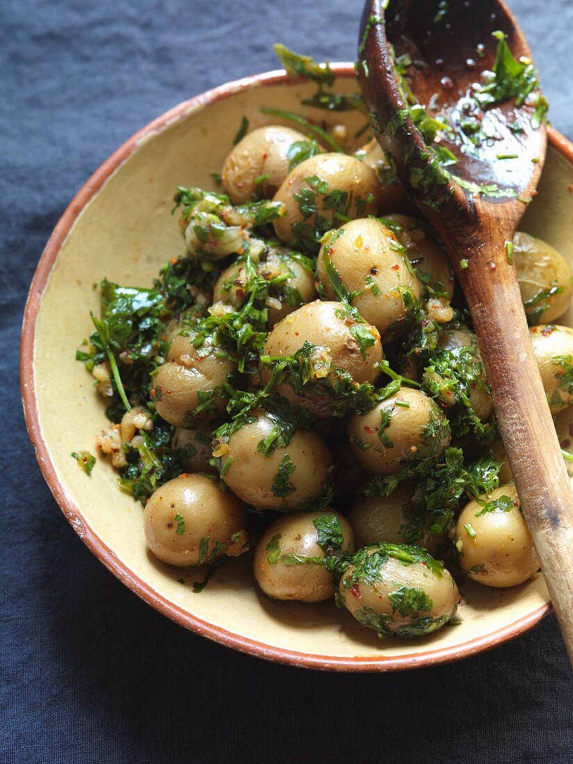 Cooked, unpeeled potatoes with parsley