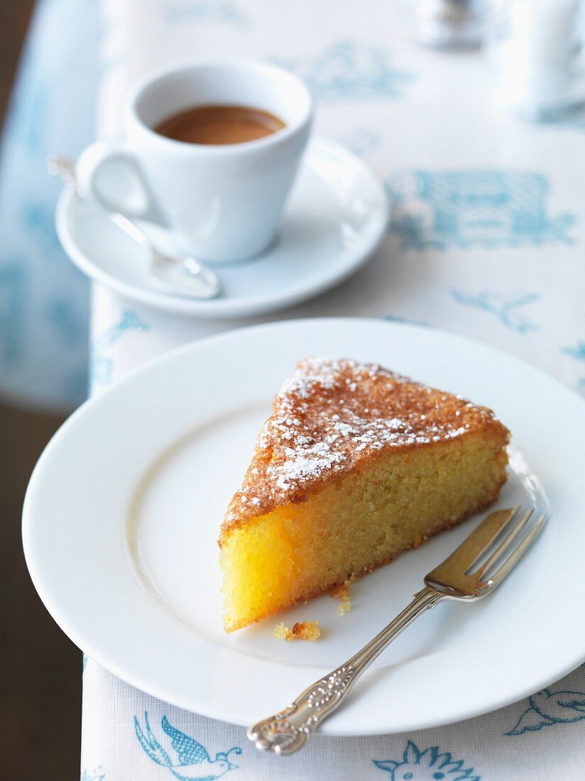 A slice of Tunisian lemon and almond cake with icing sugar