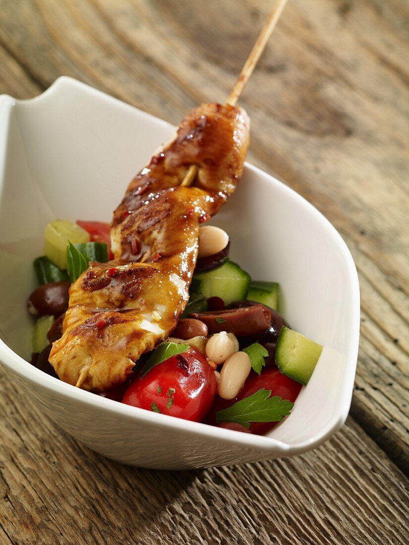 A turkey skewer with a vegetable salad