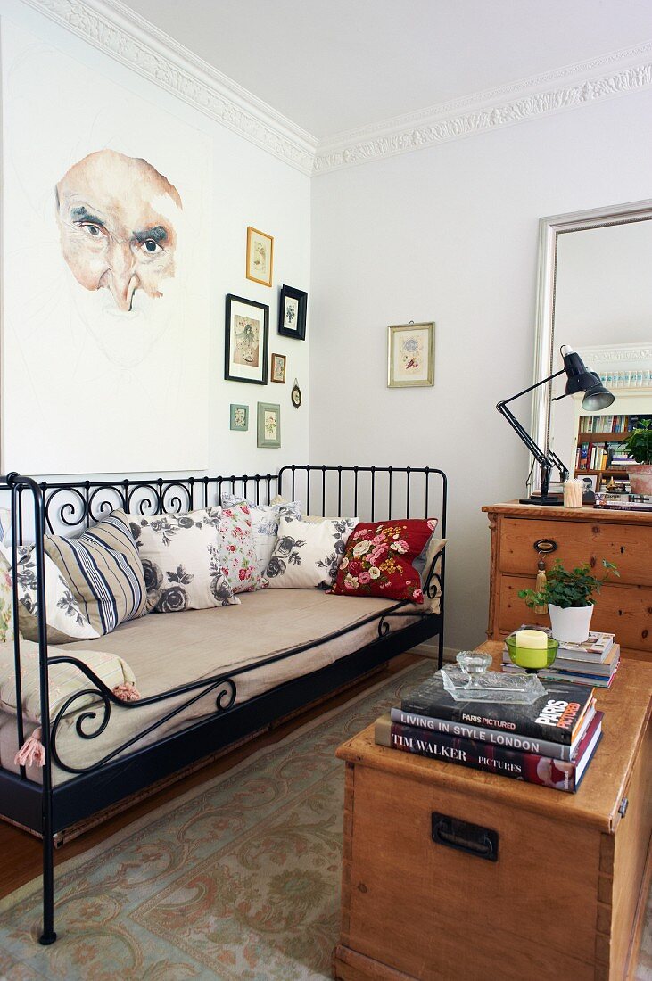 Wooden trunk opposite black, vintage metal daybed in living room