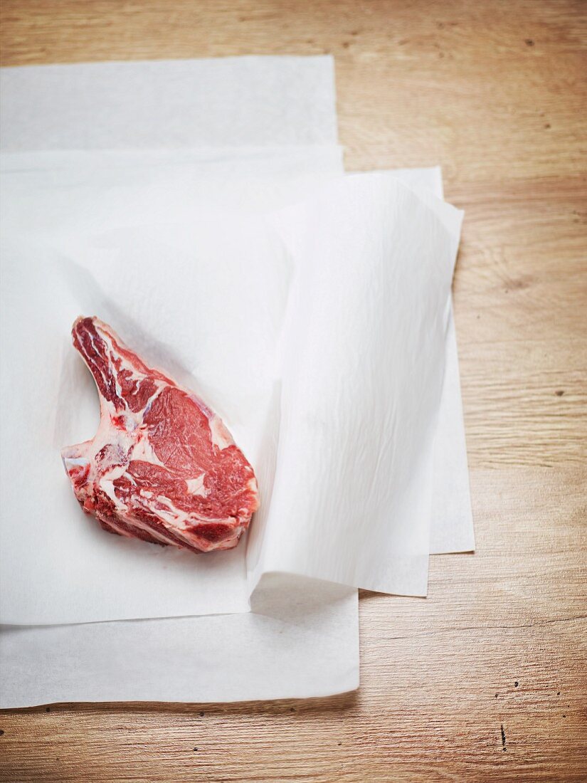 A veal chop on a piece of white paper