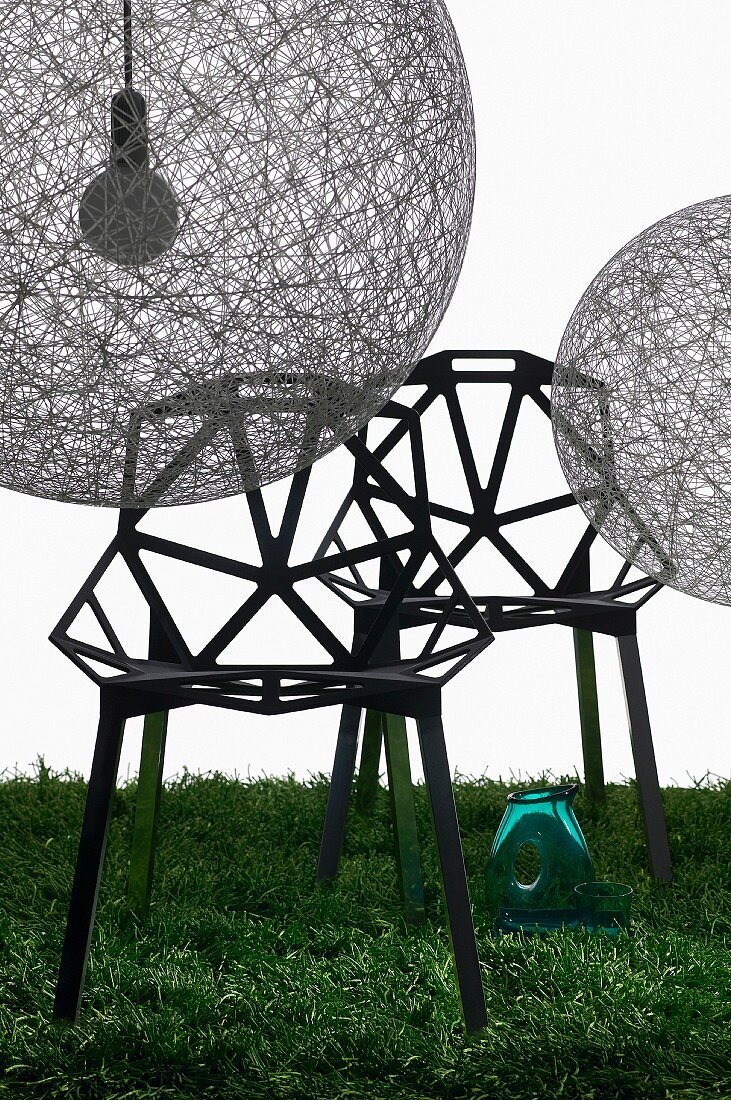 Ballonförmige Hängeleuchten (Random Light) aus Fiberglas-Gewebe und sternförmig verstrebte Designerstühle auf Rasen