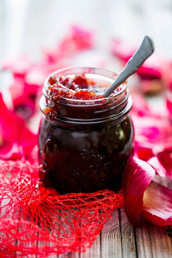 A jar of red onion chutney with a spoon