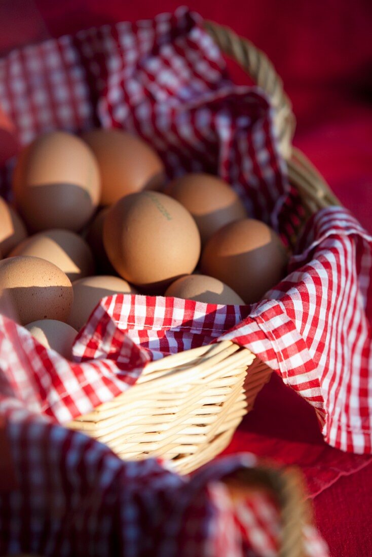 Fresh eggs in a basket lined with a checked cloth