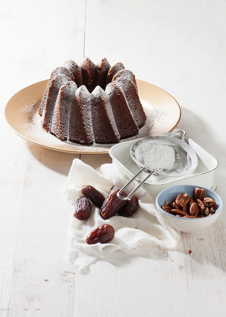 Bundt cake with dates, pecan nuts and icing sugar