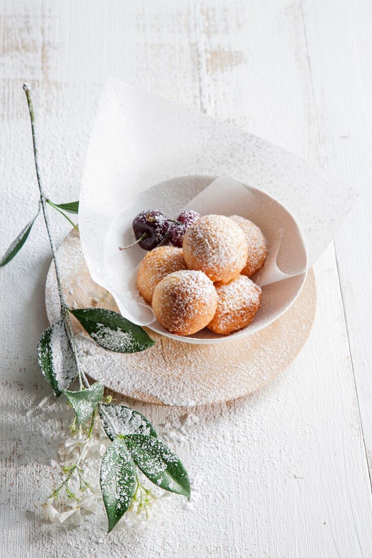 Ricotta dumplings with icing sugar and cherries
