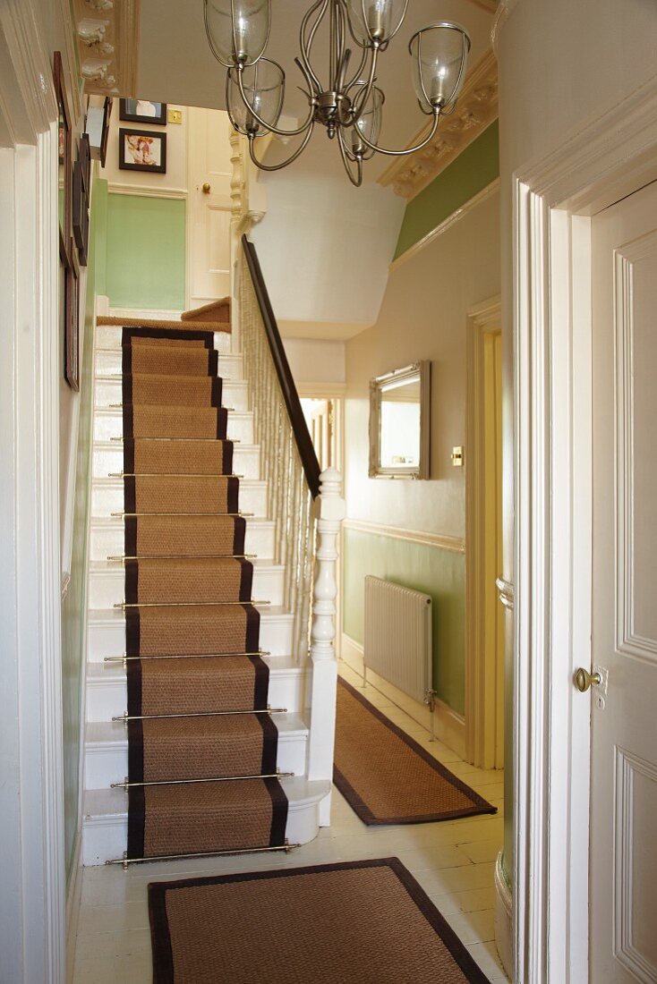 Staircase with runner and traditional hallway in English house