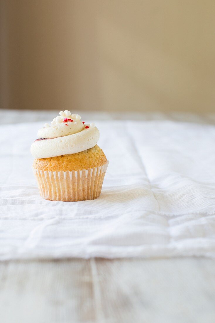 Vanillecupcake mit Vanillesahne, Beeren und Zuckerstreuseln