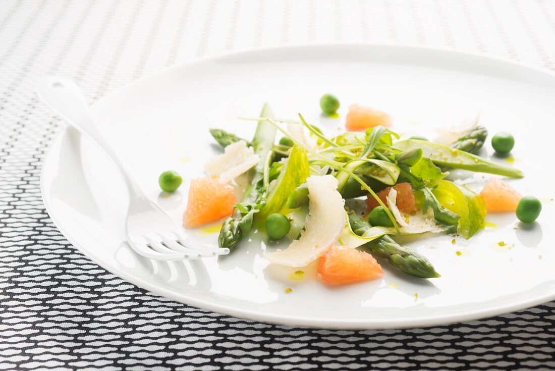 A spring salad with asparagus, parmesan, peas, grapefruit and green tomatoes