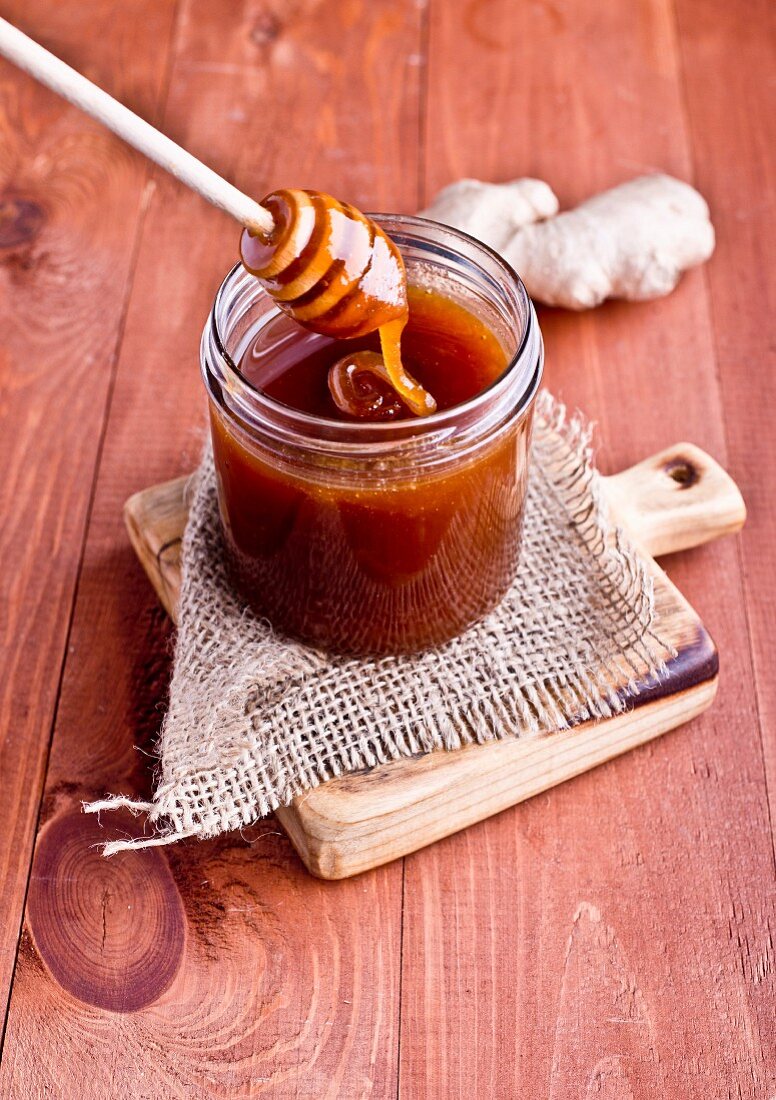 A jar of honey with a spoon