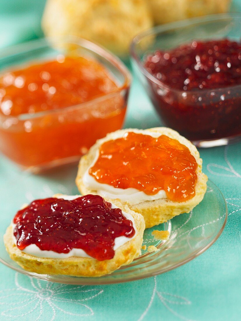 Scones with clotted cream, strawberry, and apricot jam