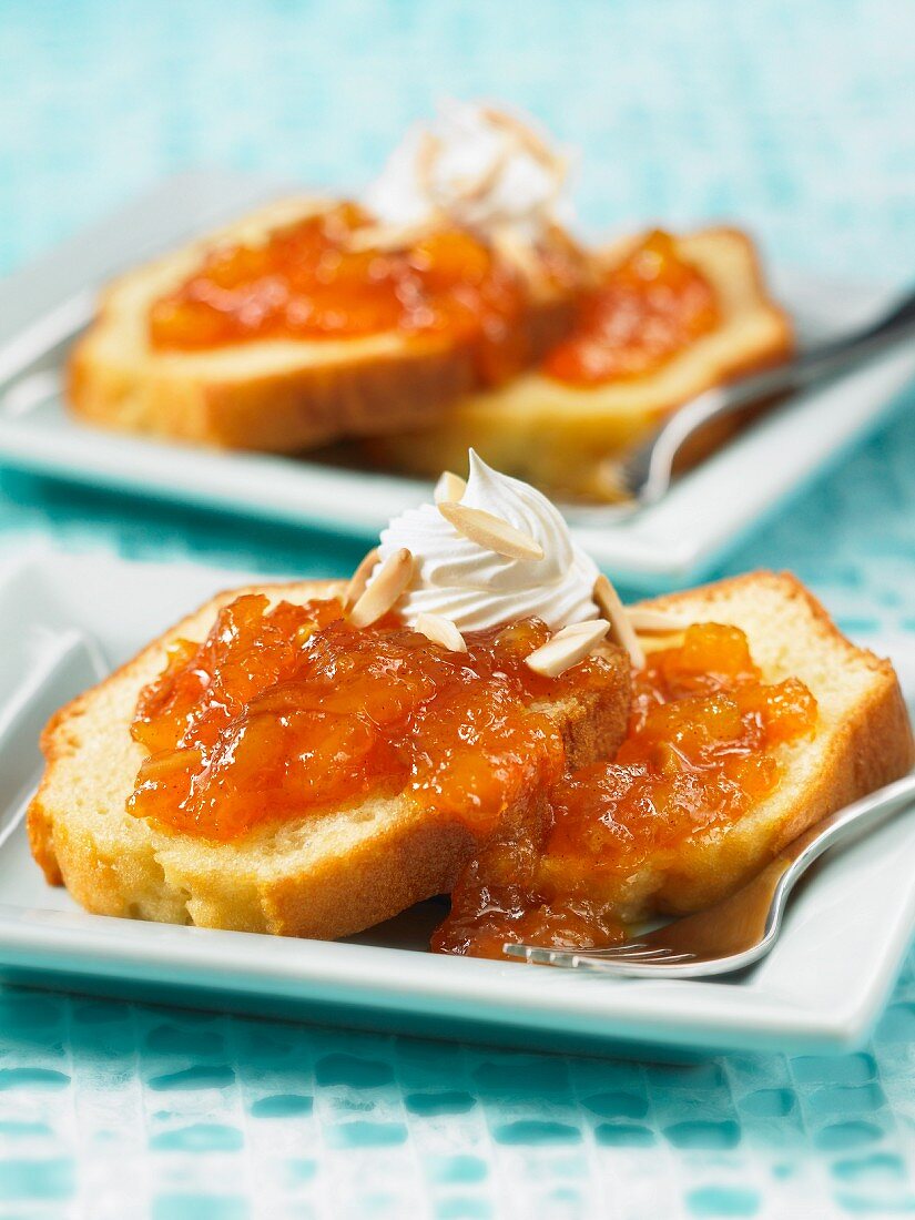 Ananas-Mango-Papayakonfitüre auf Kuchenstücken mit Schlagsahne