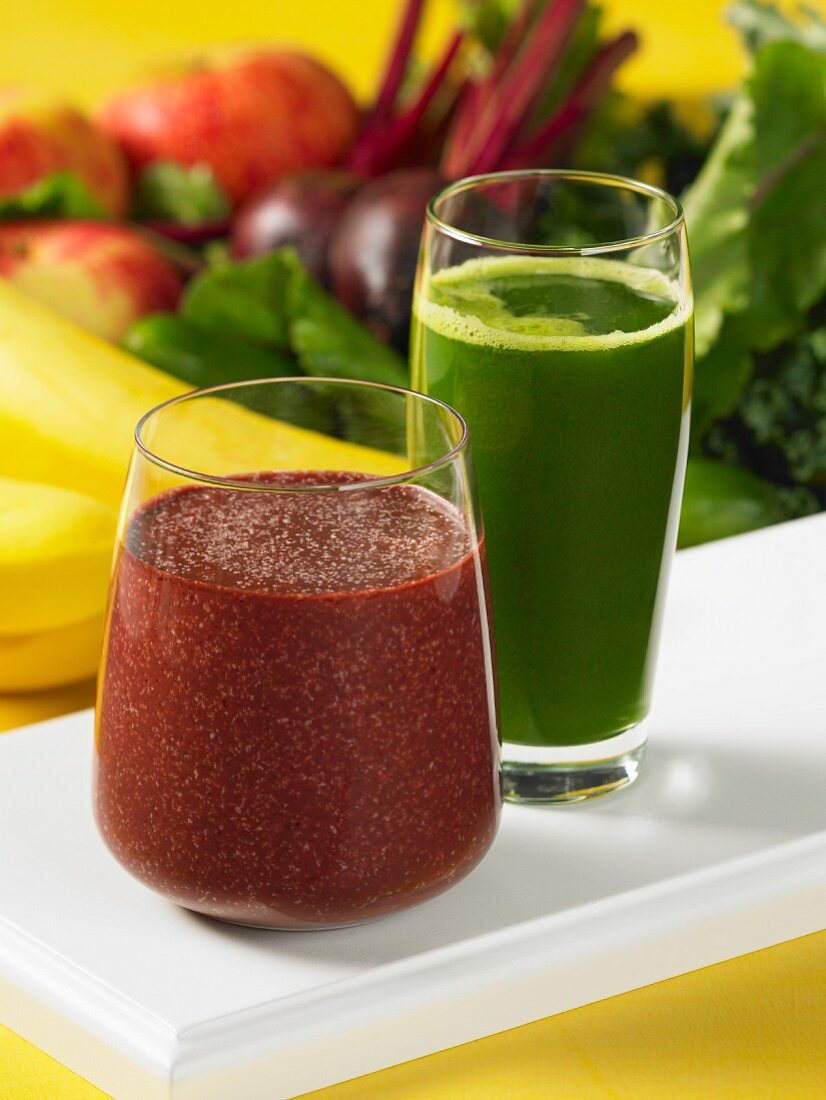 Grüner und roter Gemüse-Frucht-Saft in je einem Glas