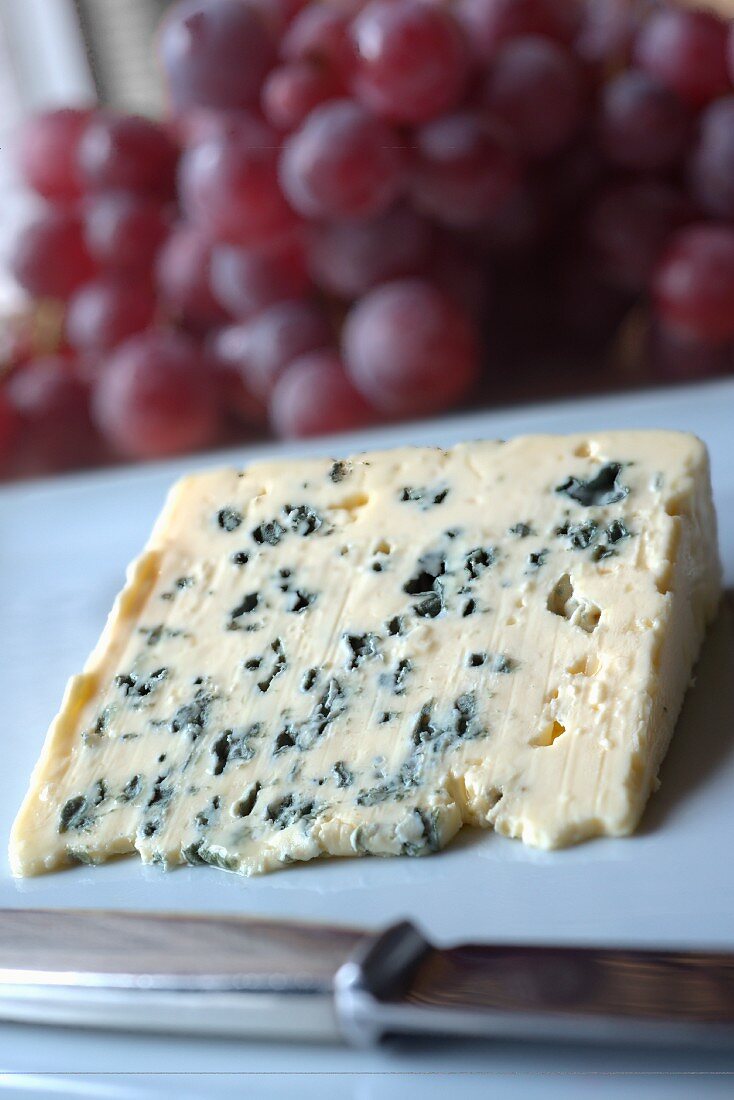 A slice of Roquefort and red grapes