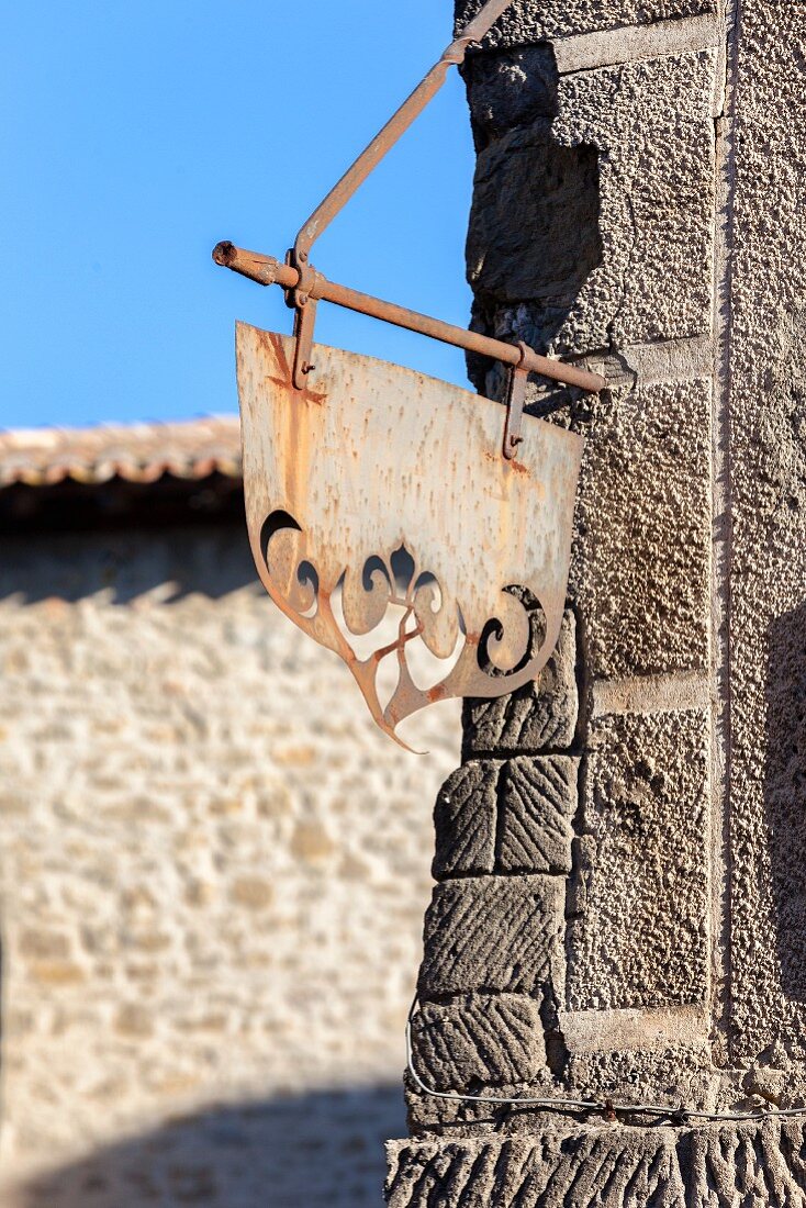 Metal sign hanging on a building in the Citadel of Carcassonne (France)
