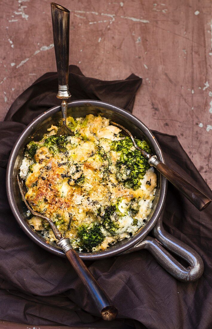 Gratinated broccoli in a baking dish with forks