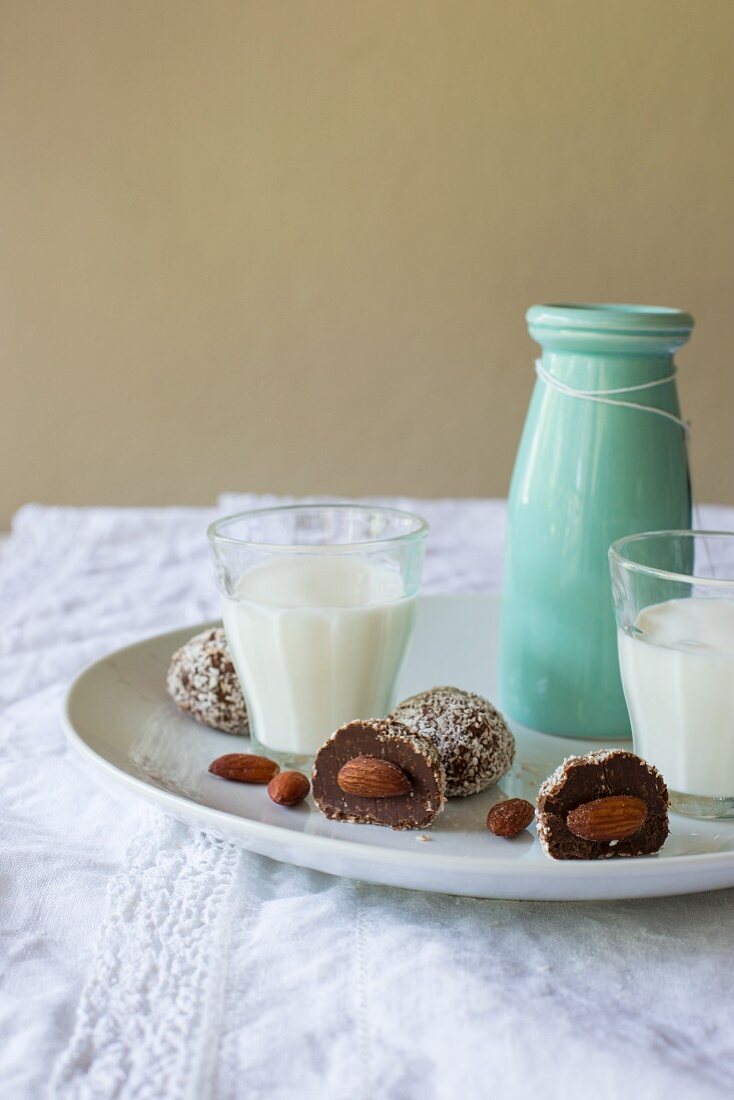 Chocolate and almond truffle pralines with grated coconut and served with milk