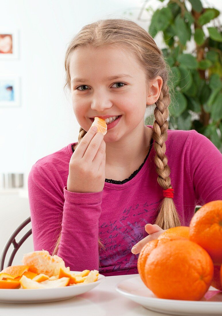 A girl eating an orange
