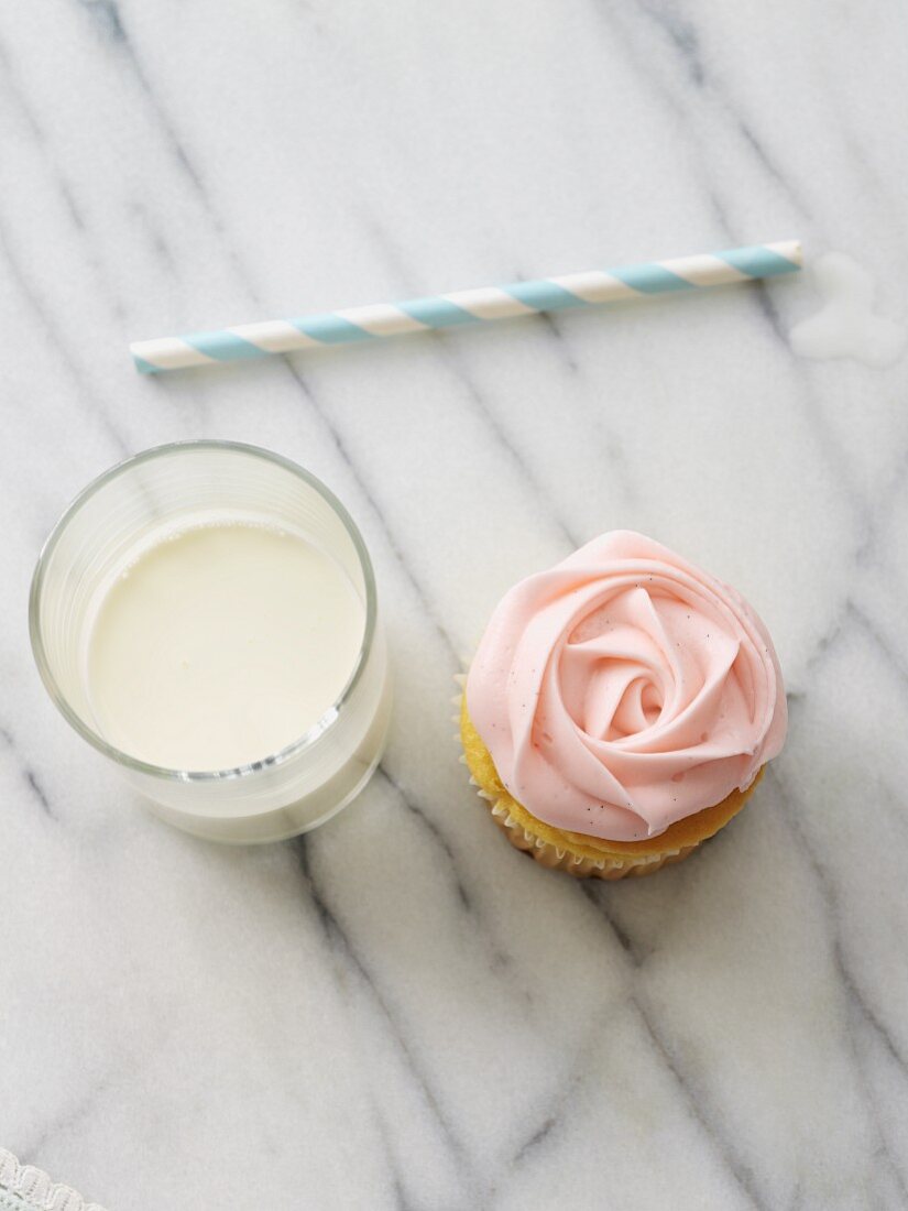Rosen-Cupcake und ein Glas Milch