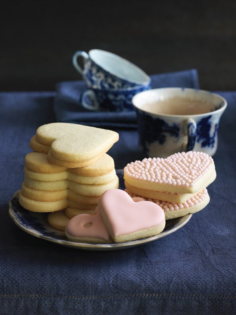 Heart-shaped cookies with pink icing served with tea