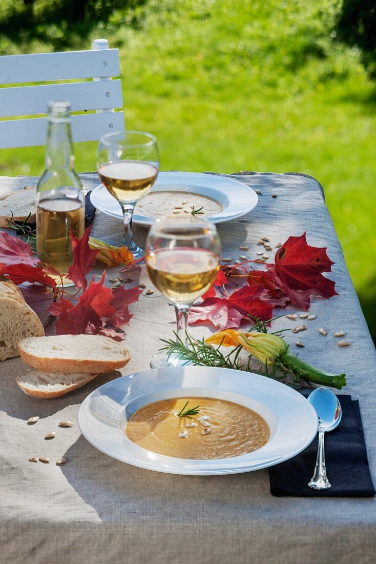 Apple and pumpkin soup outside on an autumnal table