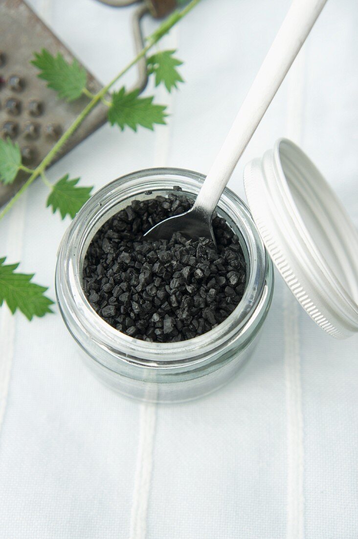 Black salt in a screw-top jar with a spoon