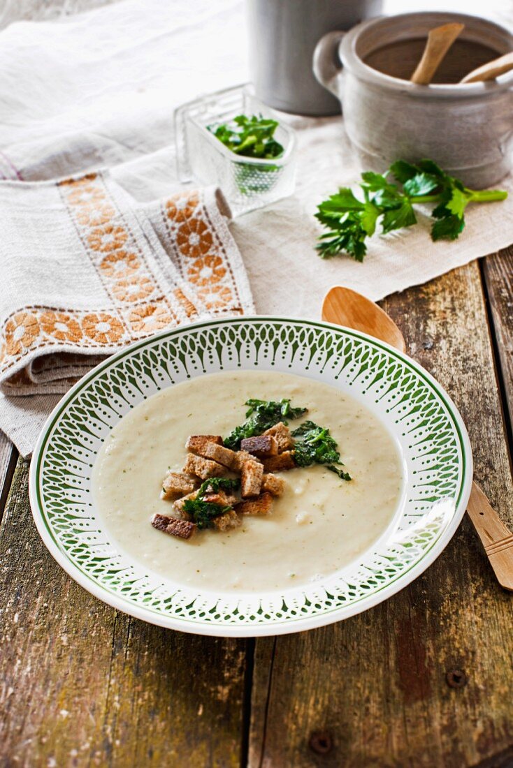 Selleriecremesuppe mit Schwarzbrot-Croûtons und geröstetem Selleriegrün