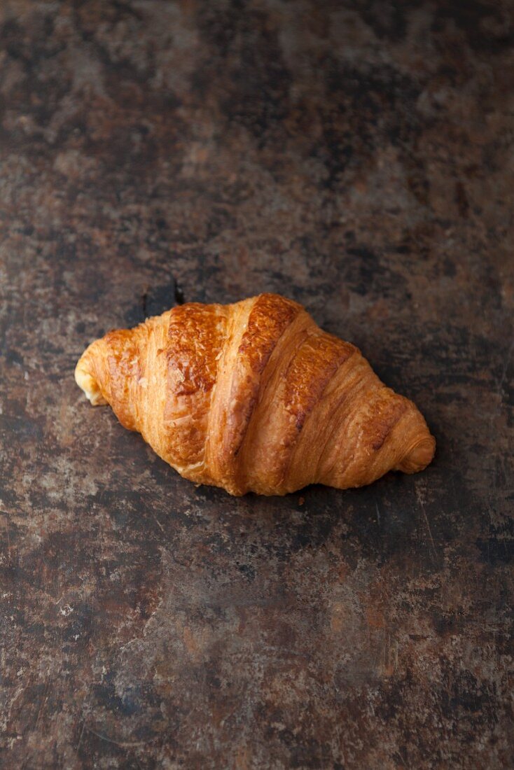 A butter croissant on a baking tray